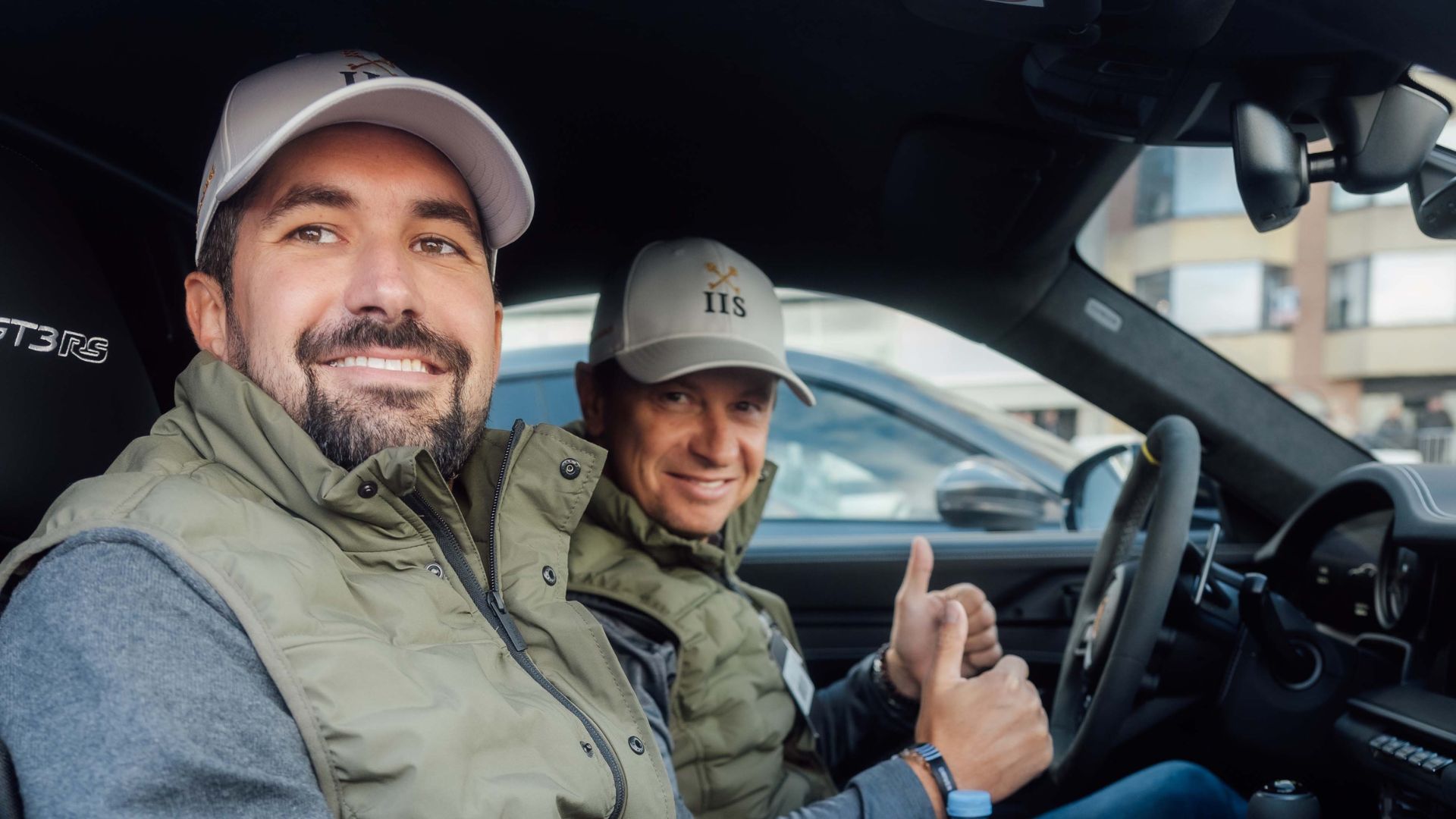 Piloot en co-piloot in de wagen, met duim omhoog